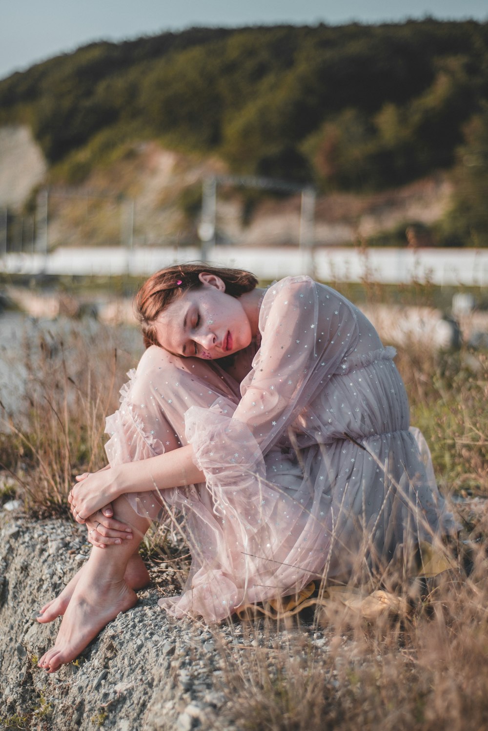 close-up photography of woman sitting on rock