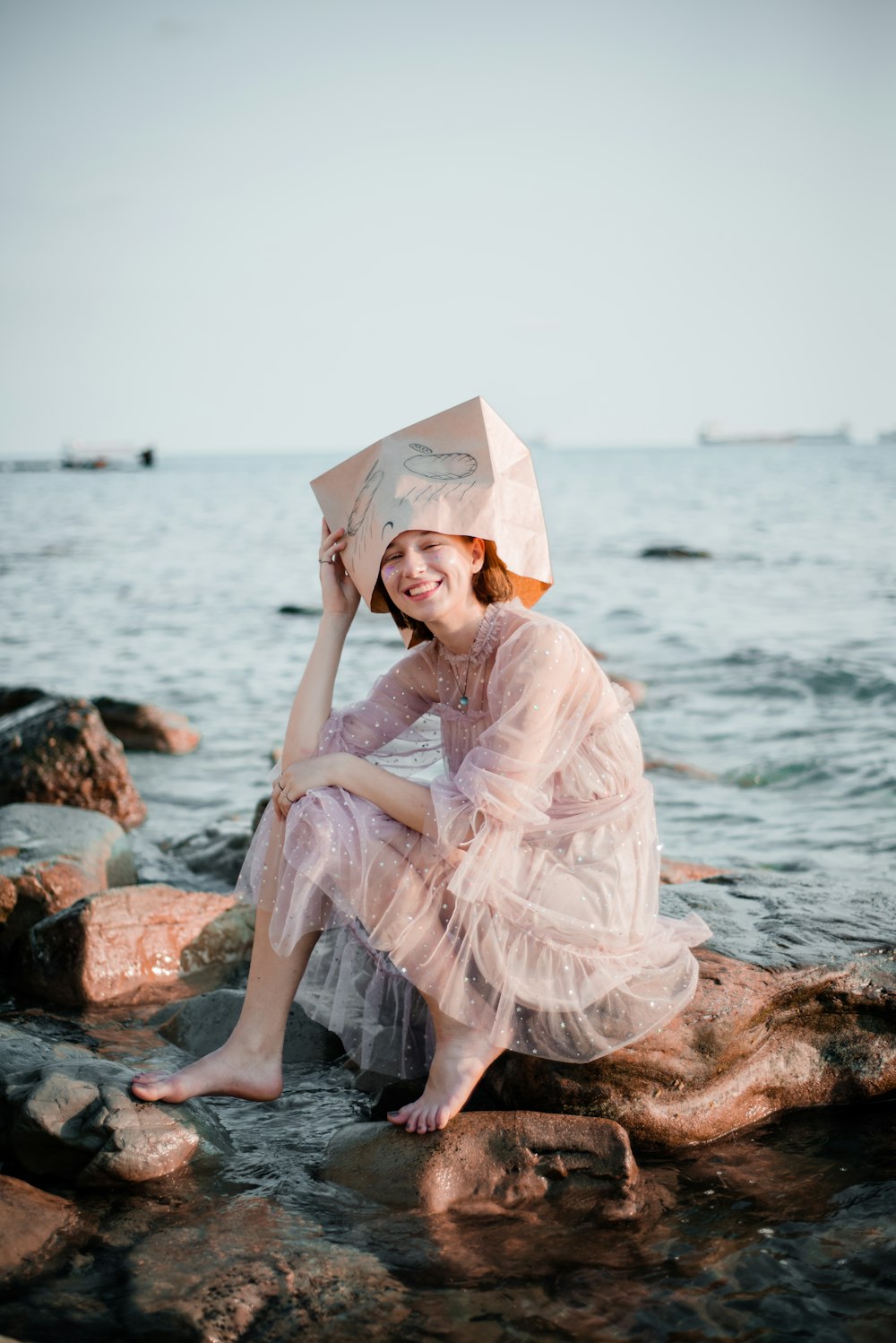 woman sits on the stone of the seashore