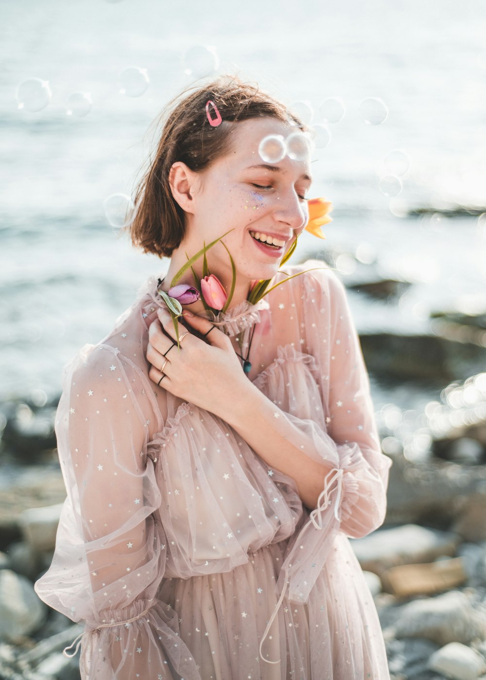 smiling woman wearing beige and white pleated maxi dress