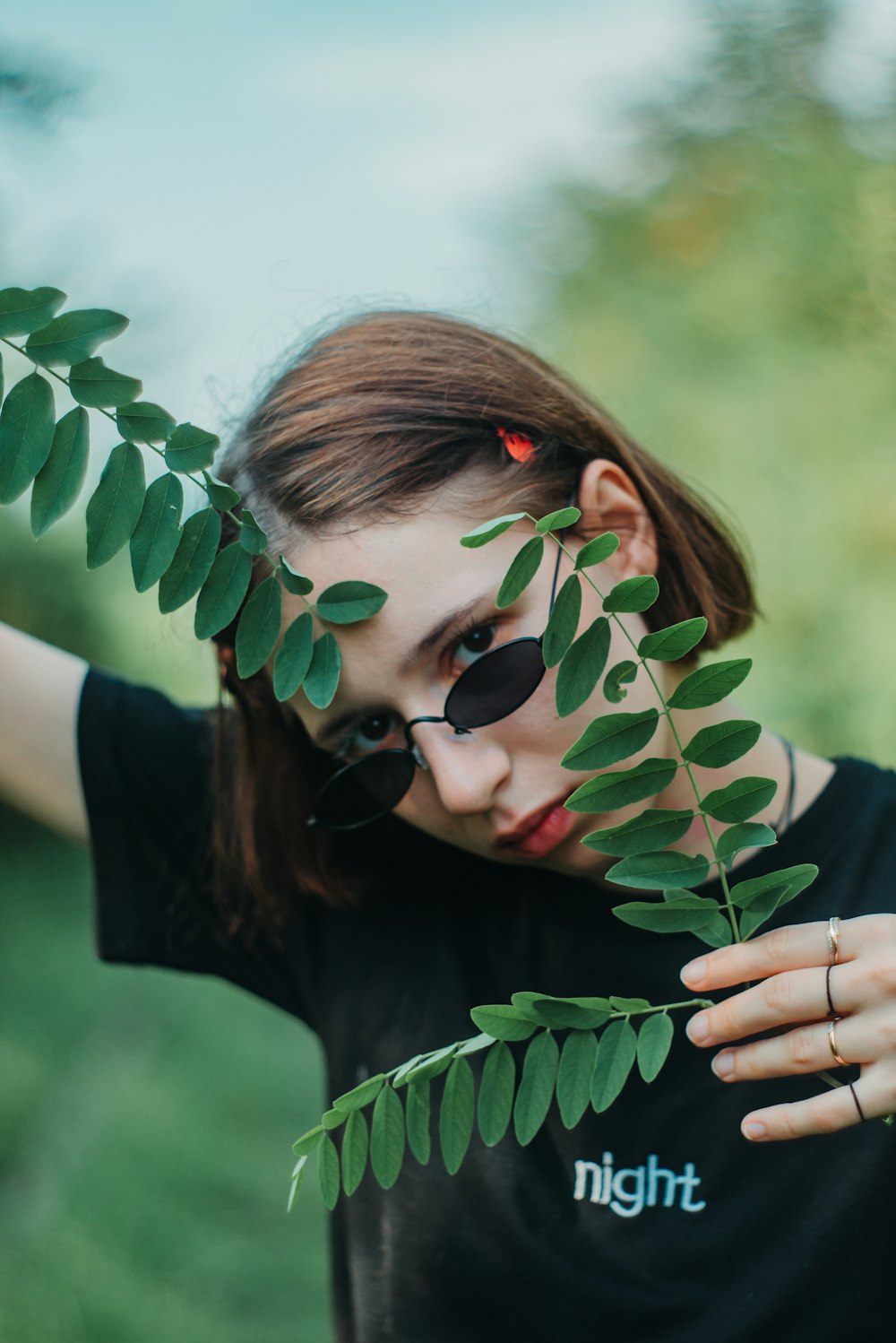 shallow focus photo of woman holding green leaves