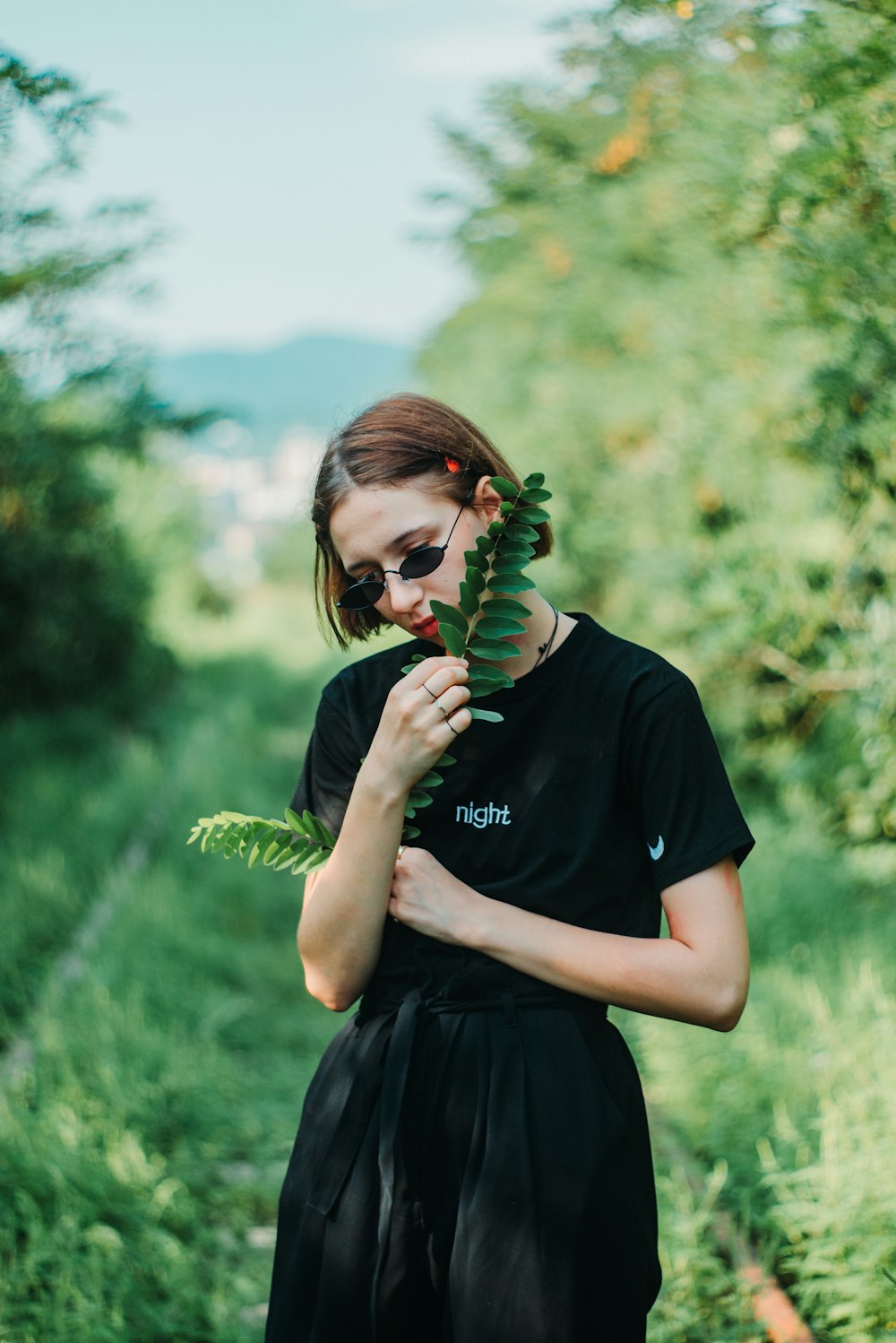 woman holding fern plants