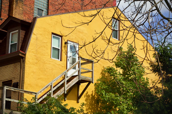 A yellow house with steep wooden steps