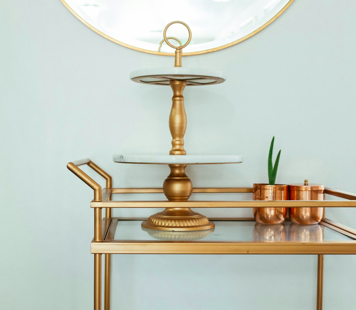 Brass bar cart styled with bottles and greenery