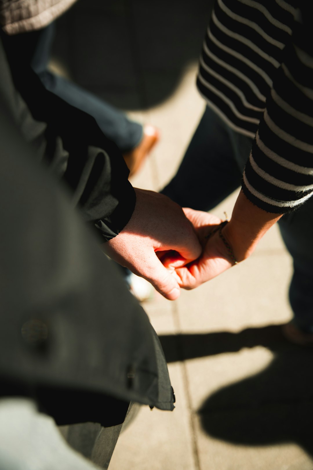 two persons holding each other hands