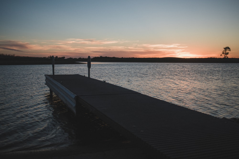 brown wooden dock on body of water