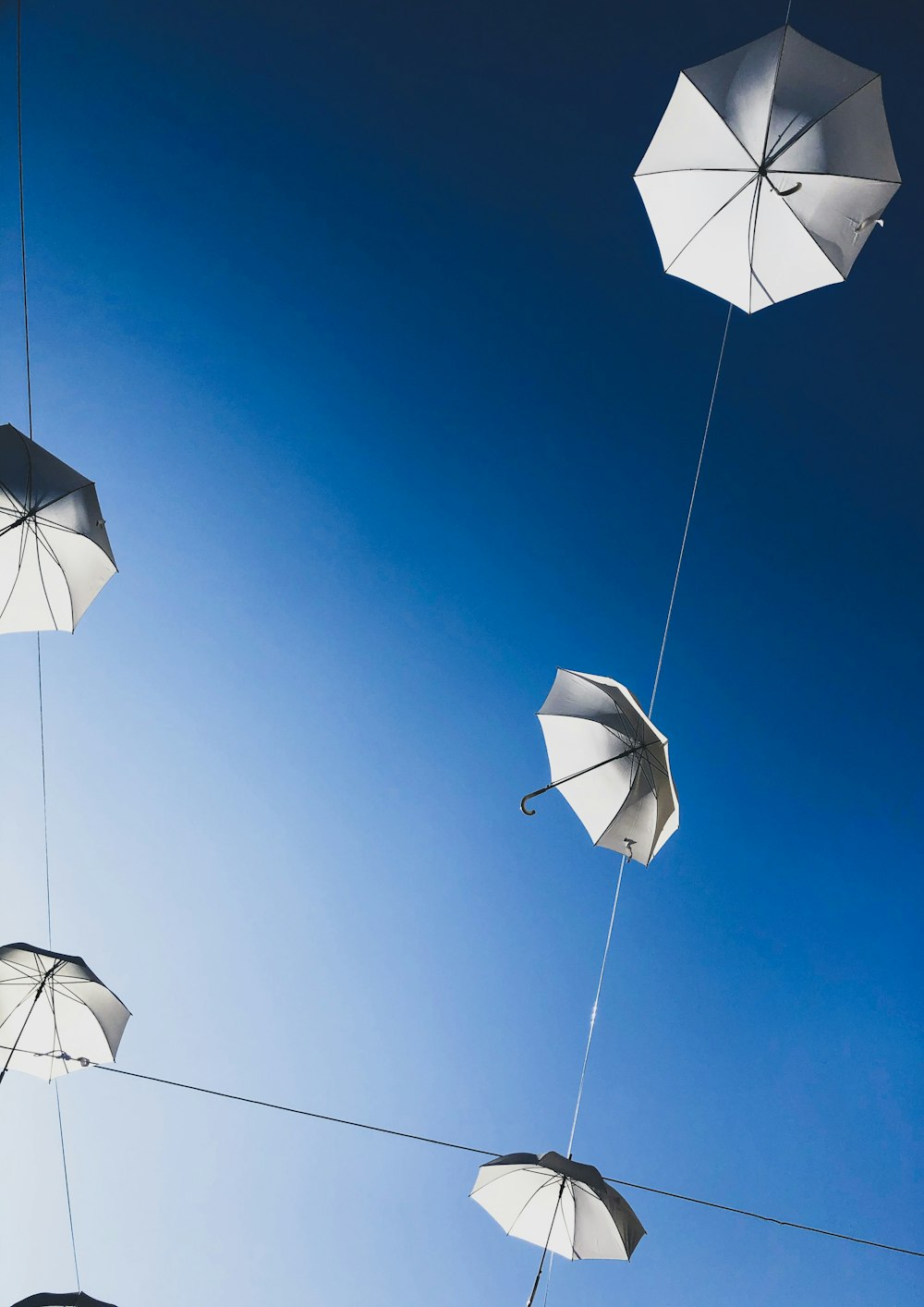 white umbrellas hanging on strings