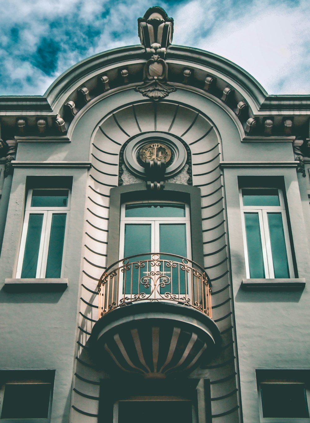 Edificio de hormigón gris y azul bajo cielos azules y blancos