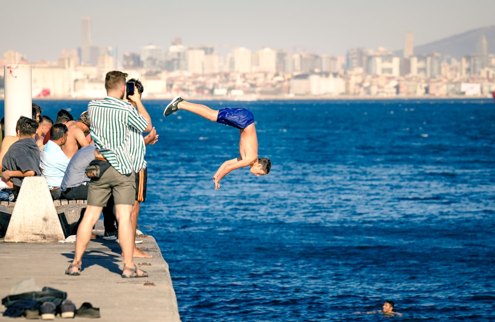 man wearing blue shorts diving during daytime