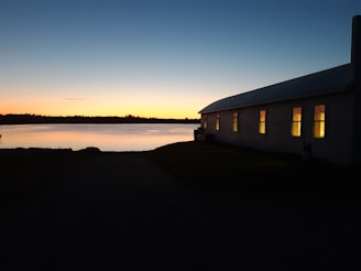 Modern office building with a serene lakeside view during sunset