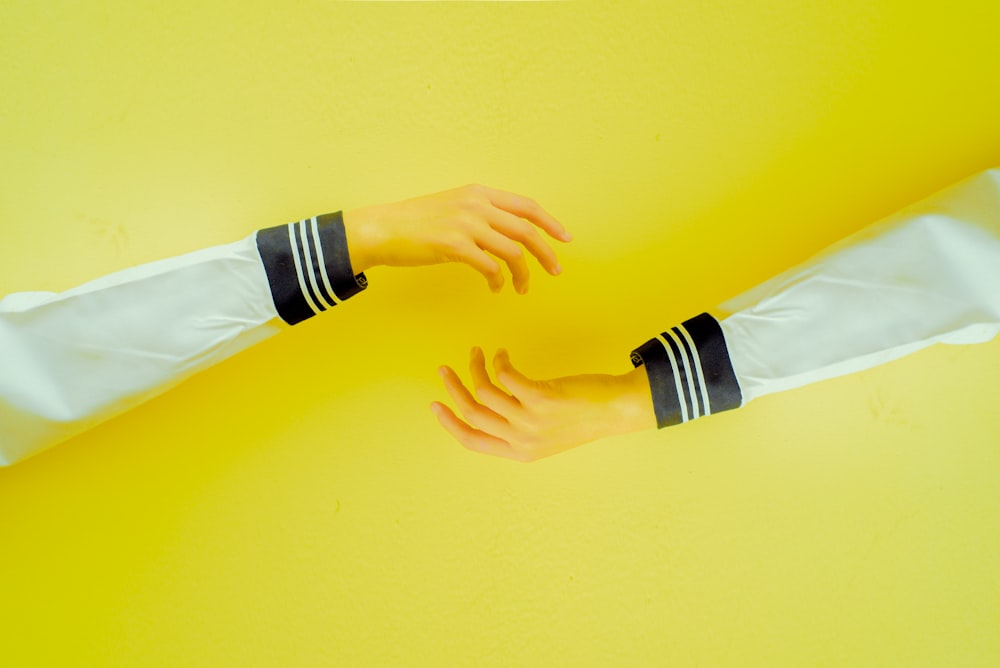 two hands reaching each other on yellow background