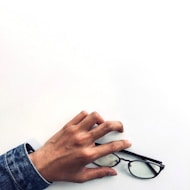 Hands fitting eyeglass frames on a customer during a consultation.