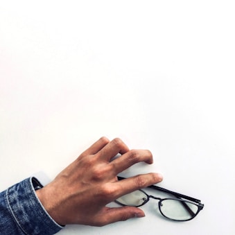 Hands fitting eyeglass frames on a customer during a consultation.