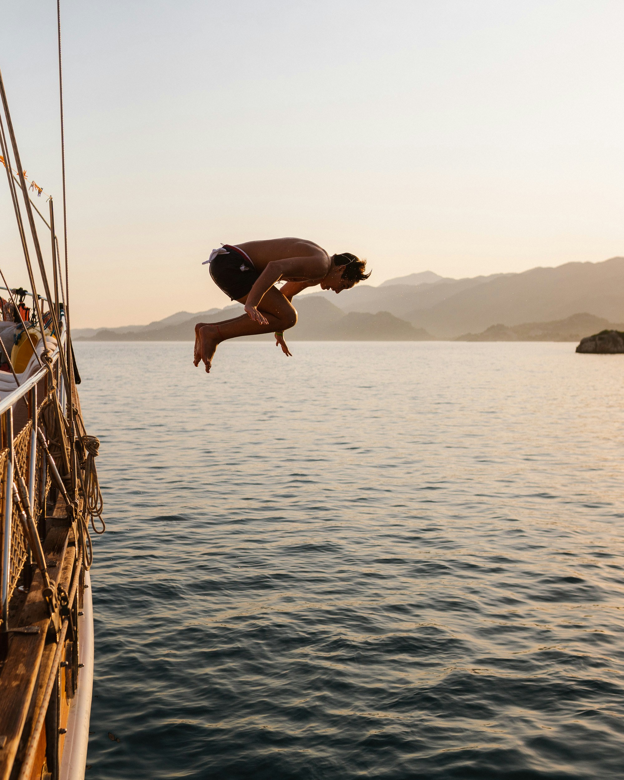 man jump over sea during daytime