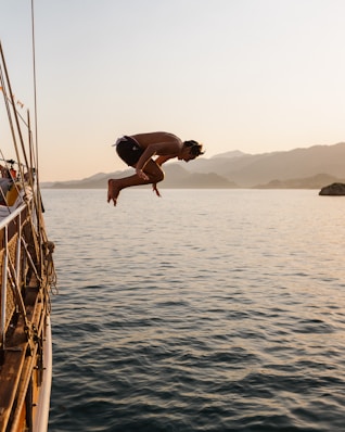 man jump over sea during daytime