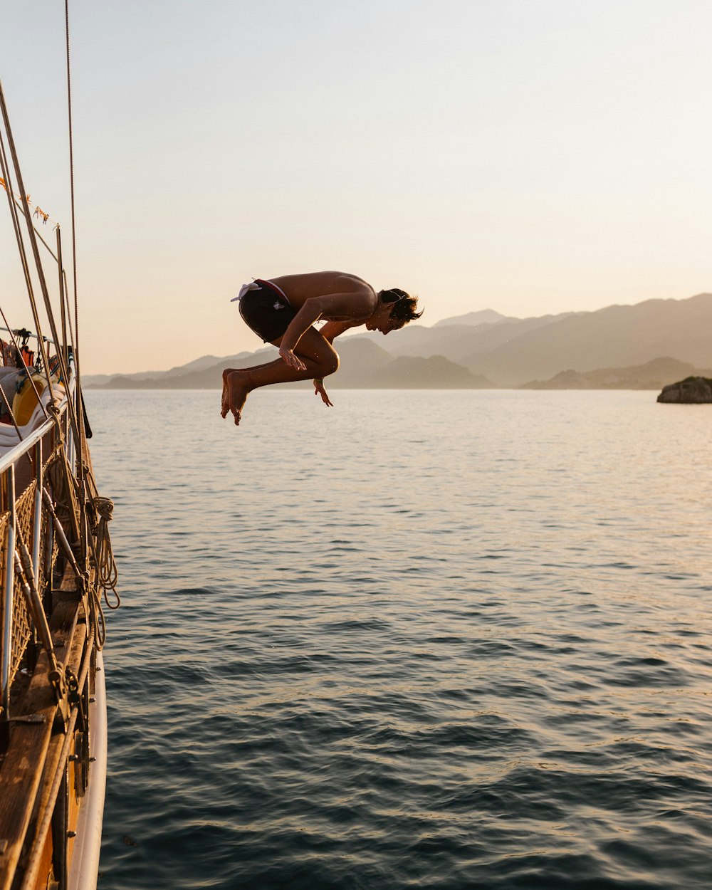 man jump over sea during daytime