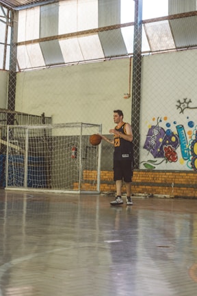 A basketball player dribbling the ball on an indoor court.