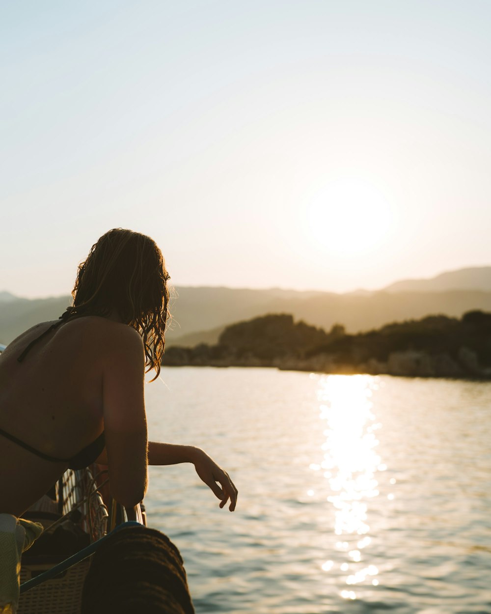 woman in black bikini top looking at body of water