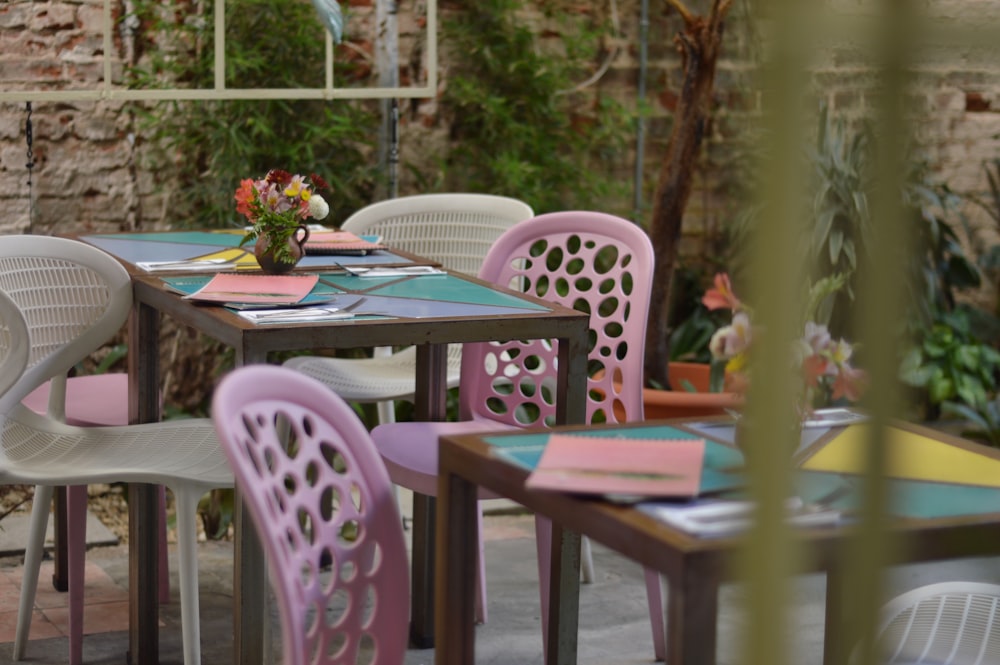 a table and chairs with a vase of flowers on top of it