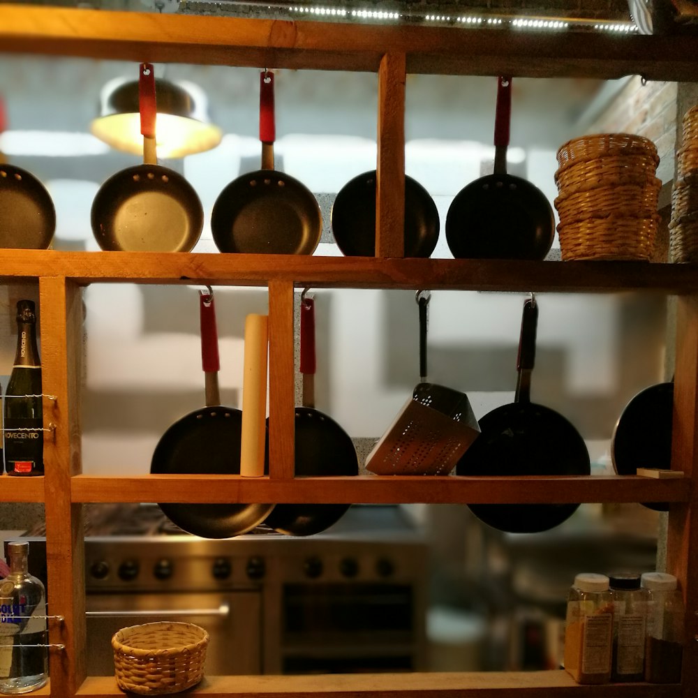 frying pans hanging on wooden rack