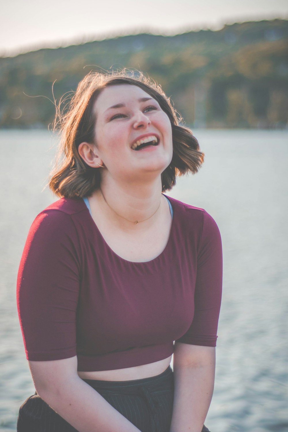 woman smiling wearing maroon scoop-neck shirt