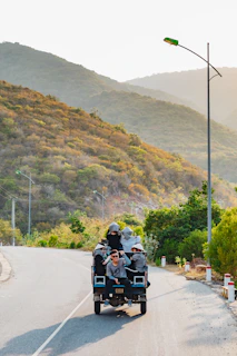 A panoramic shot of a winding road through the hills, with a Supersafri vehicle making its way along the route.