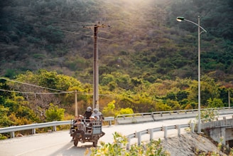 A group of tourists riding quadricycles on a rugged mountain trail in Monte Verde with lush greenery around.