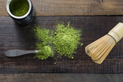 Close-up of vibrant green matcha powder in a traditional wooden bowl.