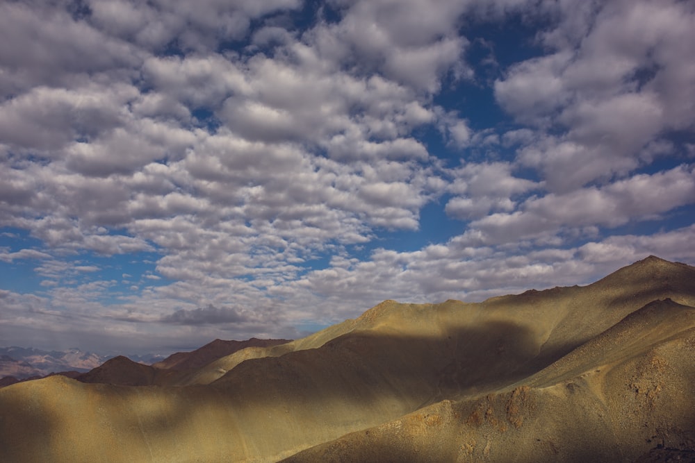 brown mountain under white clouds