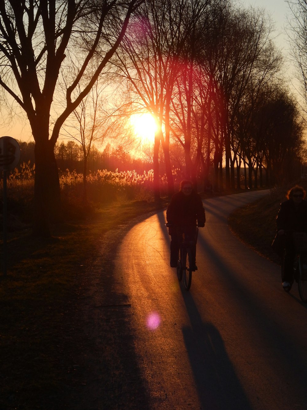 2 personas montando en bicicleta durante la puesta de sol