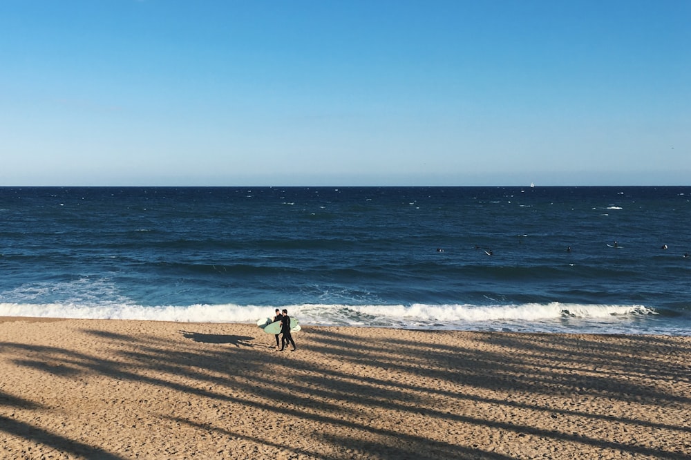 Persona que camina junto a la orilla del mar durante el día