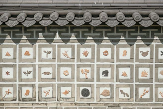 Artisans restoring traditional Puebla tiles on a historic wall.