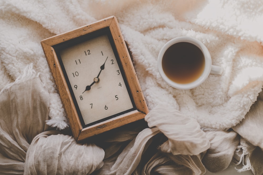 cup of coffee beside rectangular desk clock displays 8:08