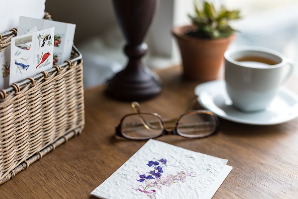 white ceramic mug beside eyeglasses