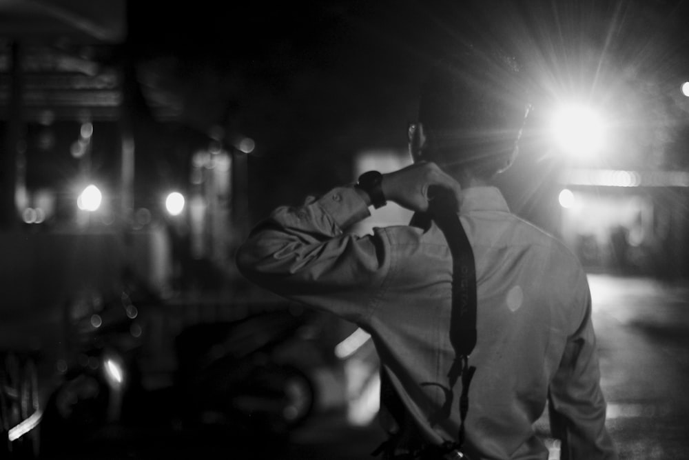 grayscale photography of man carrying bag