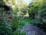 A lush, well-manicured garden pathway bordered by colorful blooming flowers.