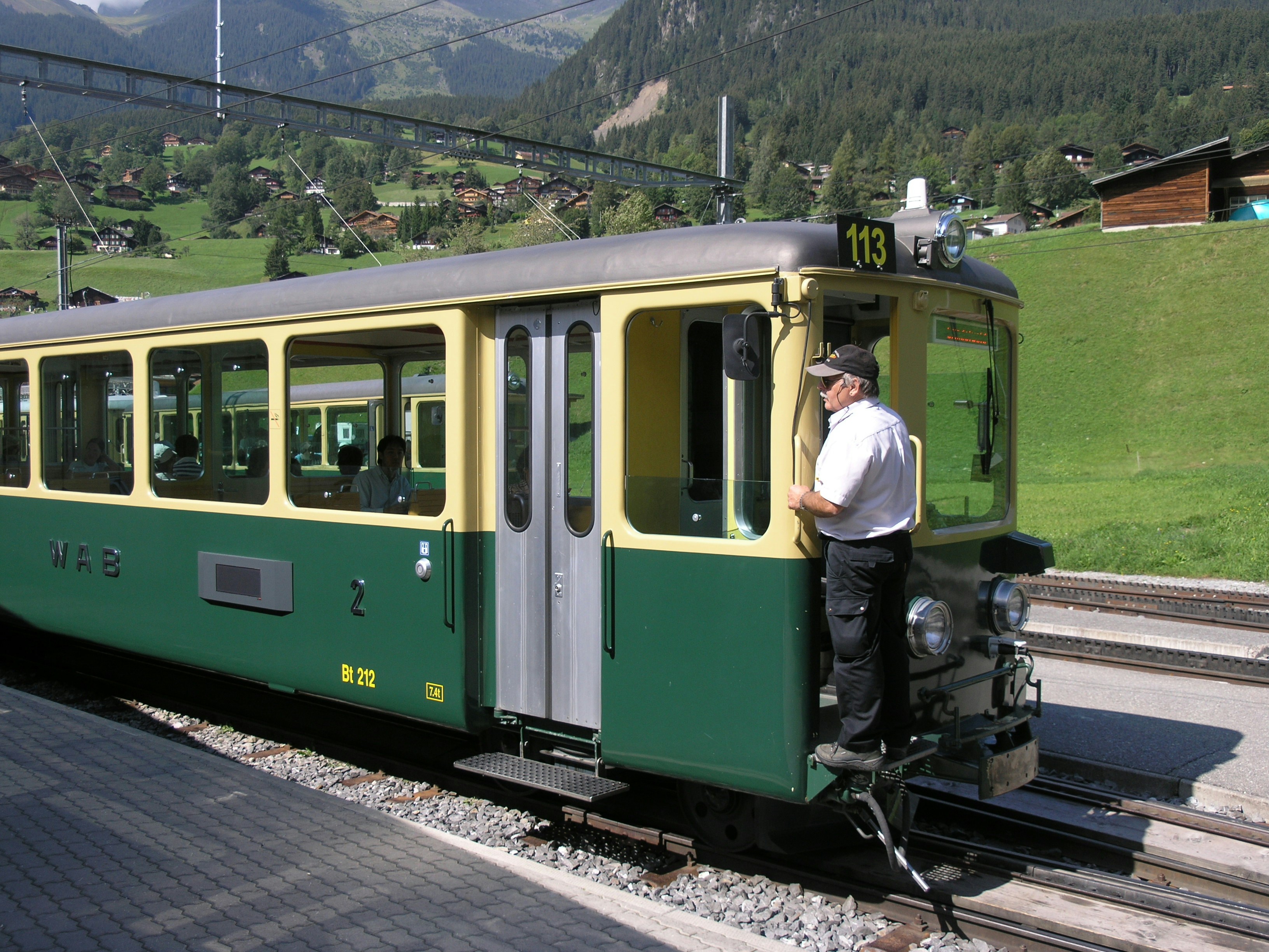 man standing outside train during day