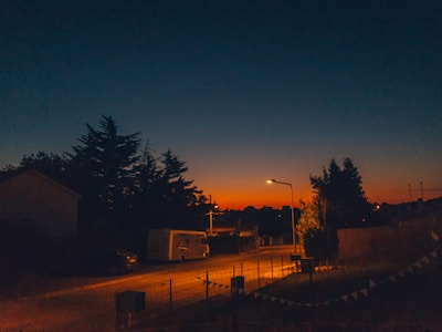 A sunset view of a quiet neighborhood with a Good Power Solutions vehicle parked nearby.