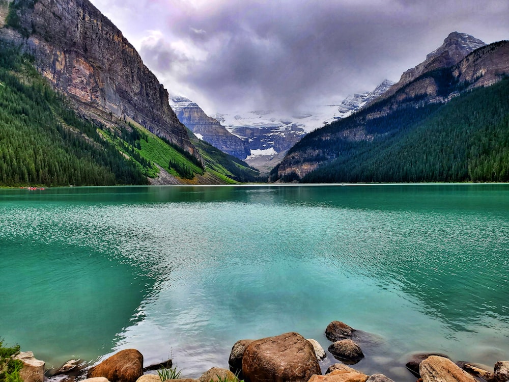 mountains near body of water under cloudy sky