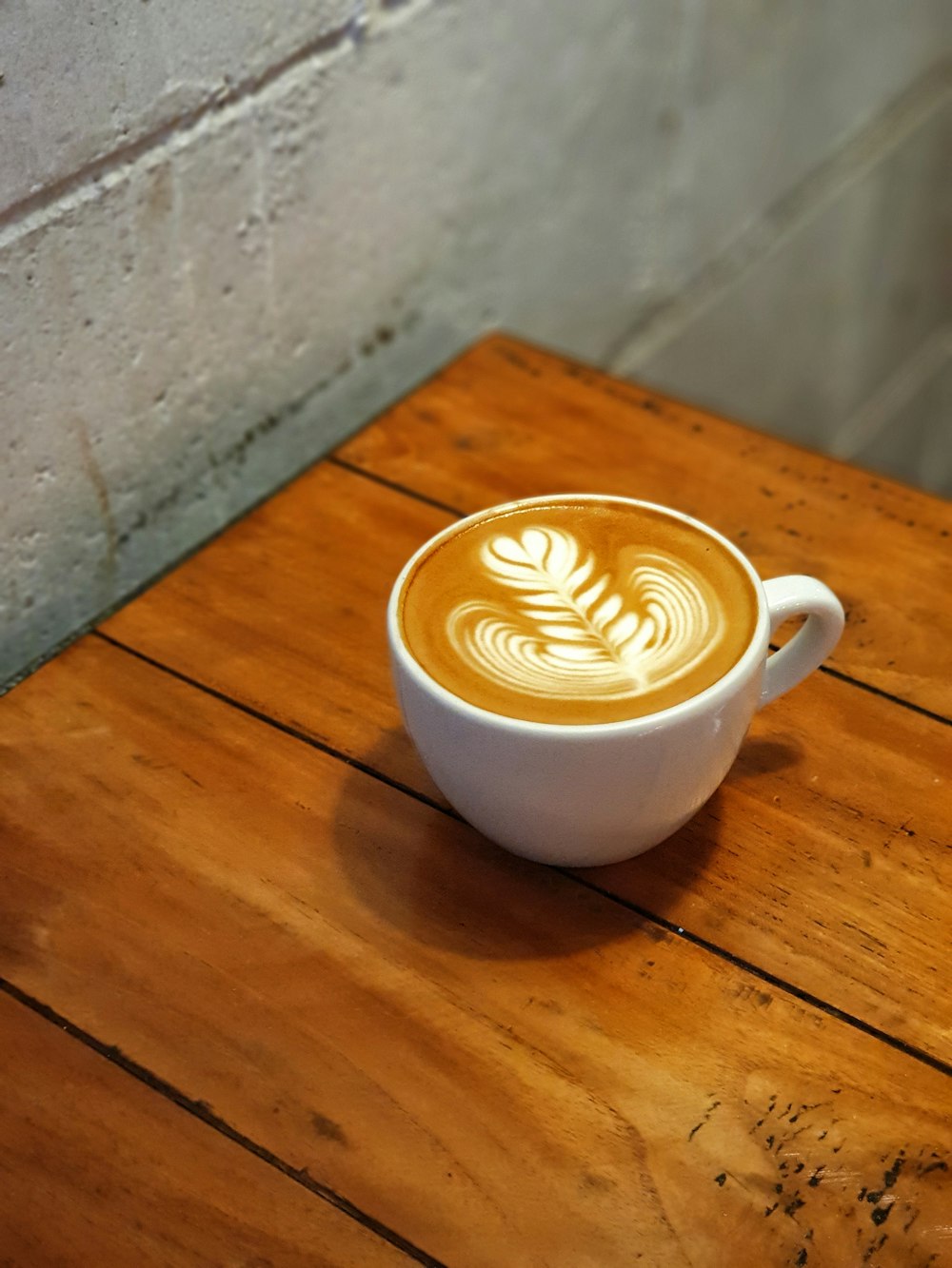 cappuccino on wooden surface
