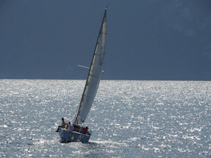 A classic 40ft sailboat gliding smoothly across the sparkling waters of Lake of the Ozarks on a sunny day.