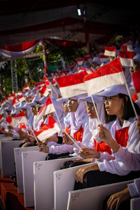 shallow focus photo of people holding Indonesia flag