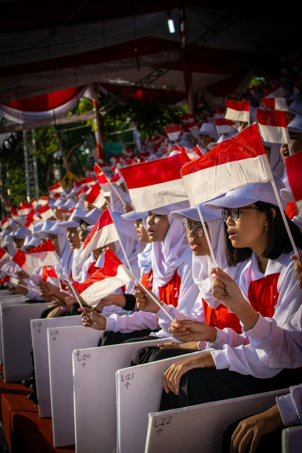 shallow focus photo of people holding Indonesia flag