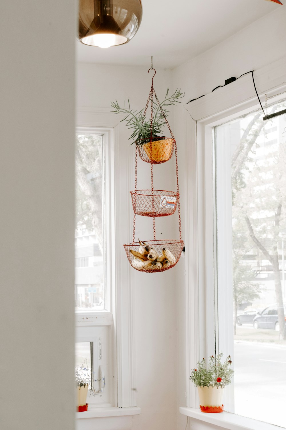 Cesta colgante de malla naranja dentro de la casa cerca de la ventana