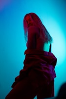 A playful scene of a camgirl teasing with soft lighting and a colorful backdrop.