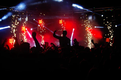 An electrifying concert crowd waving hands under colorful stage lights in Mumbai.