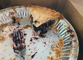 one sliced pie left in tray near gray stainless steel fork