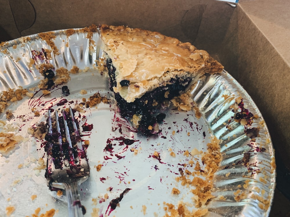 one sliced pie left in tray near gray stainless steel fork