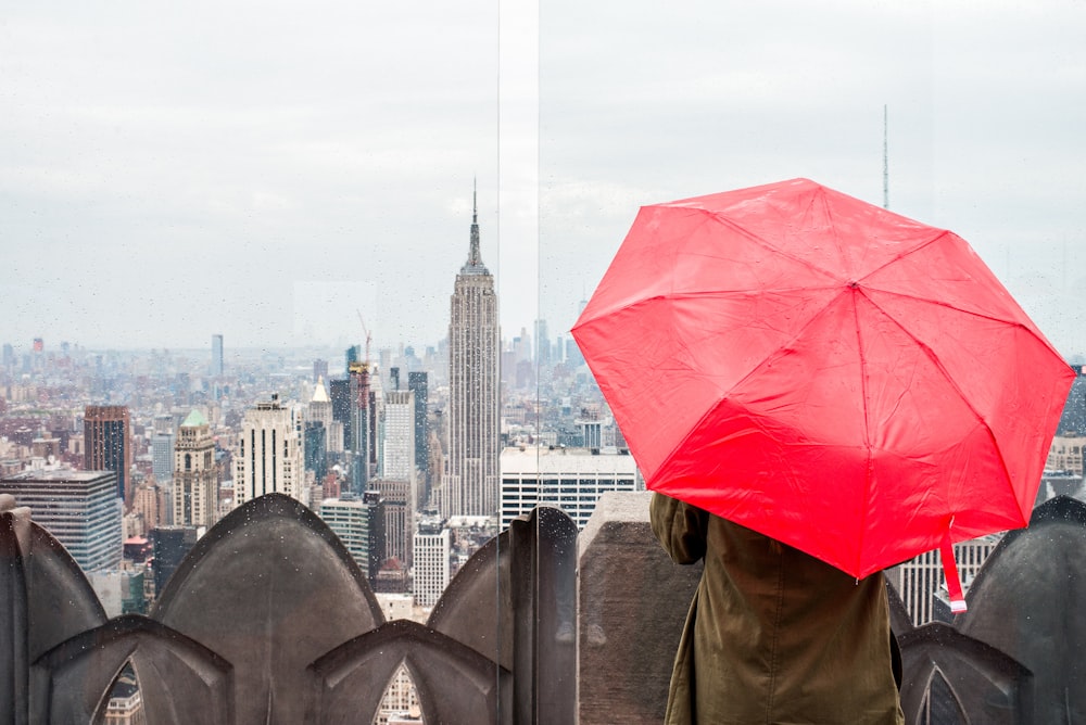 personne tenant un parapluie rose