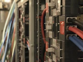 Electrical cables and panels neatly installed inside a control room with safety signs.