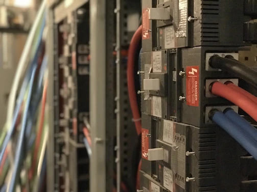 An electrical manager reviewing complex wiring diagrams on-site at a bustling data centre.